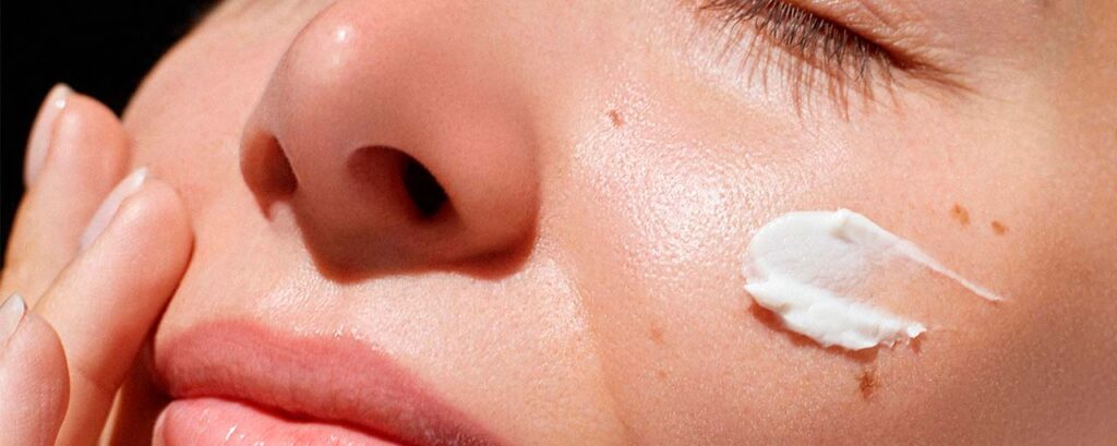 Primer plano de una piel hidratada con crema en el rostro, parte de una rutina de skincare