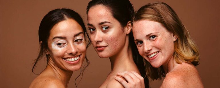 Tres mujeres con diferentes tipos de piel aplicando crema en el rostro